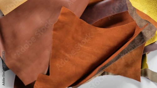 Genuine cow leather in warm brown and yellow tones.Pieces of leather flying down. leather texture backdrop 