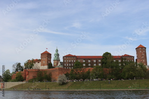 The Wawel Royal Castle and Cathedral Basilica in Krakow, Poland. Tourist boats on Vistula river with Wawel Castle in the background.