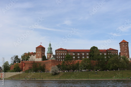 The Wawel Royal Castle and Cathedral Basilica in Krakow, Poland. Tourist boats on Vistula river with Wawel Castle in the background.