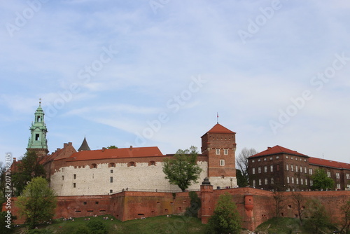 The Wawel Royal Castle and Cathedral Basilica in Krakow, Poland. Tourist boats on Vistula river with Wawel Castle in the background.