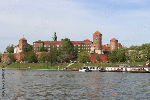 The Wawel Royal Castle and Cathedral Basilica in Krakow, Poland. Tourist boats on Vistula river with Wawel Castle in the background.