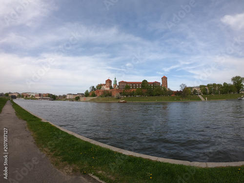 The Wawel Royal Castle and Cathedral Basilica in Krakow, Poland. Tourist boats on Vistula river with Wawel Castle in the background.