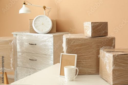 Cuadro en lienzo Packed cardboard boxes and wrapped furniture in a room