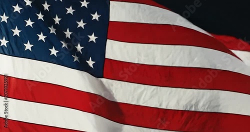 American flag waving slowly against a dark background.