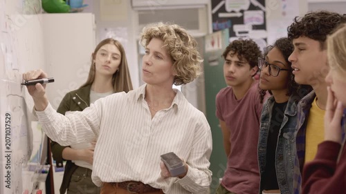 High school teacher giving lesson to multiethnic students