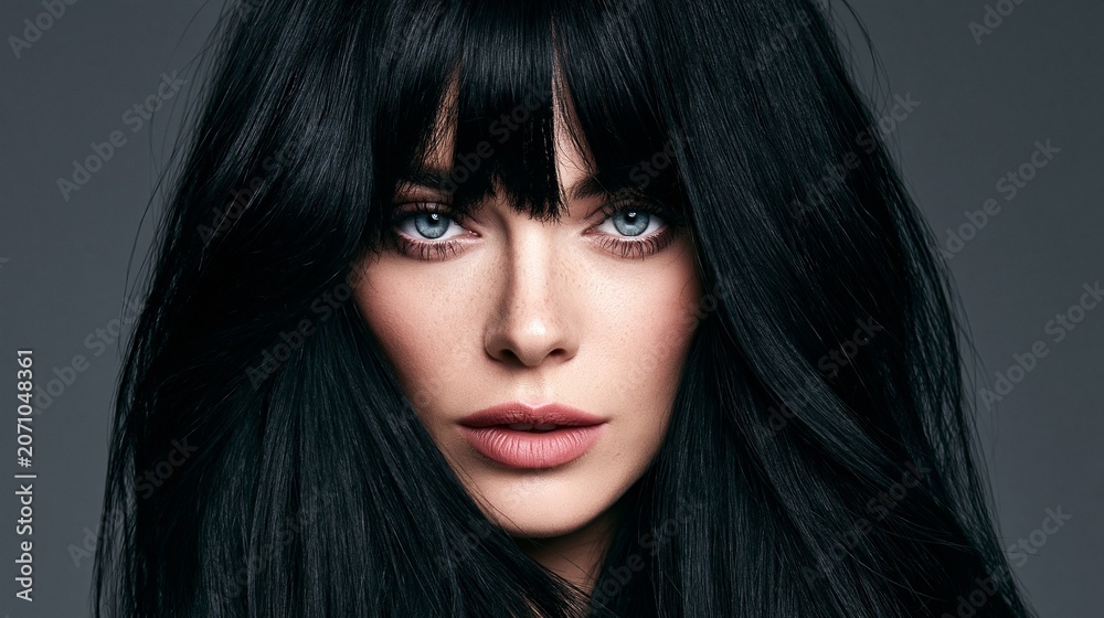Fototapeta premium Portrait of a brunette woman with layered hair and curtain bangs