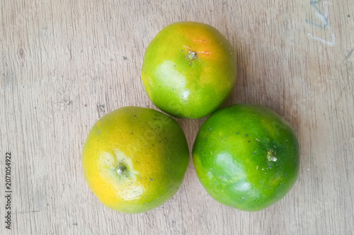 three oranges isolated on a wooden board