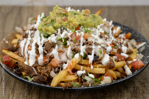 Принти на полотні Enormous plate of asada french fries covered in sour cream, guacamole, and cheese