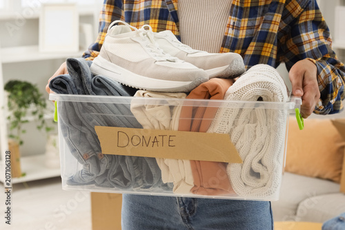 Foto Person holding a box of clothes and shoes for donation