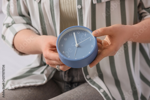 Woman changing clock in bed...