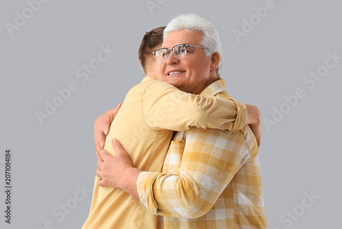 Senior man and his son hugg...