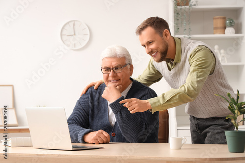 Senior man and his son watc...