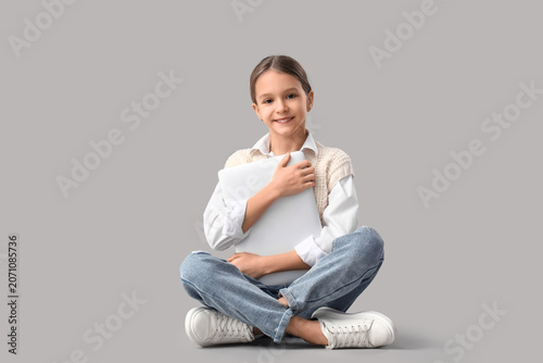 Cute girl hugging laptop on...