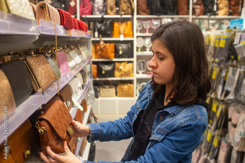 Foto Woman deciding about her new purse on the store