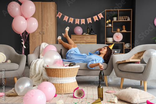 Quadro su tela Young Asian woman with hangover lying on sofa after Birthday party at home