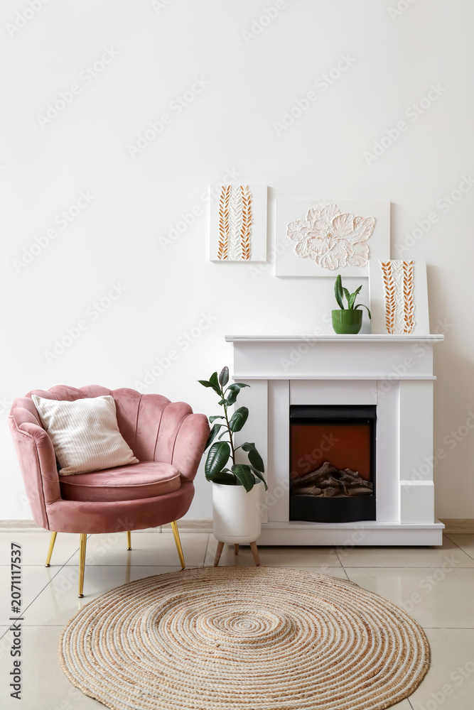 Obraz premium Interior of stylish living room with paintings, armchair and fireplace