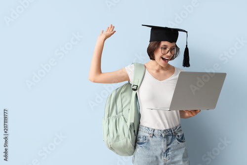 Happy female student in gra...