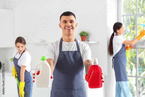 Male janitor with bottles o...