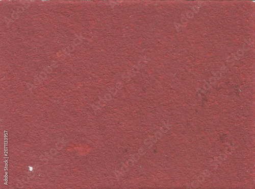 Vintage brick red colored handmade paper texture filled with rustic dark organic flecks and fiber inclusions. High-detail macro background surface optimized for eco-friendly branding, craft invitation