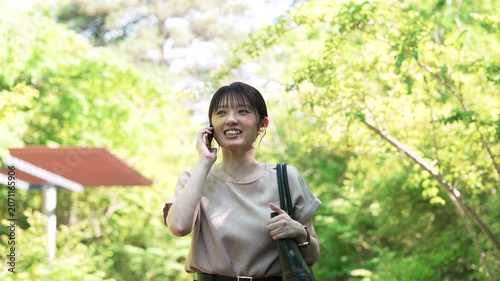 歩きながらスマートフォンで通話をする女性, Woman Talking on a Smartphone While Walking