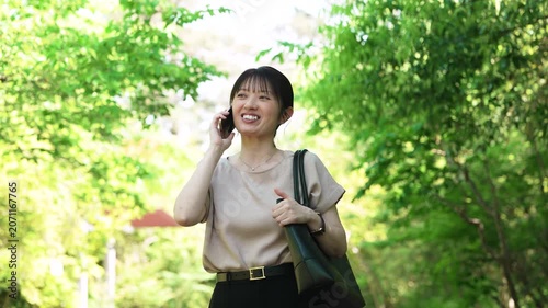 歩きながらスマートフォンで通話をする女性, Woman Talking on a Smartphone While Walking