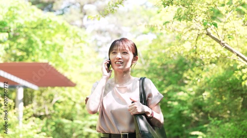 歩きながらスマートフォンで通話をする女性, Woman Talking on a Smartphone While Walking