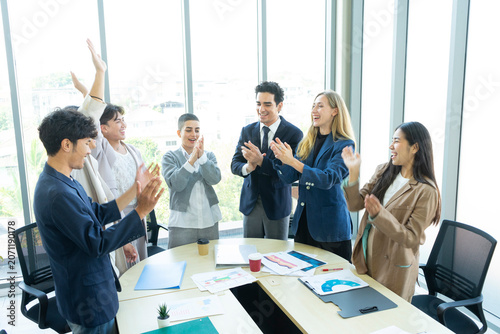 Group of business people joining hands together in office. Teamwork concept.