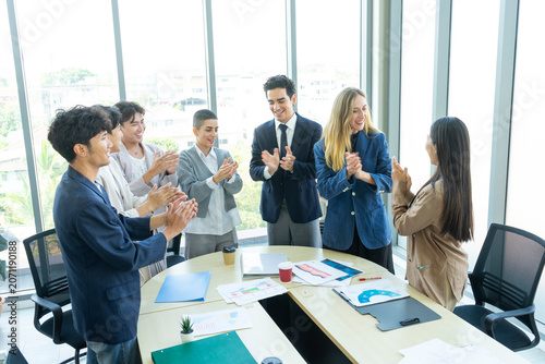 Group of business people joining hands together in office. Teamwork concept.