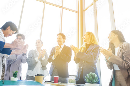 Group of diverse business people celebrating success with raised hands in the office
