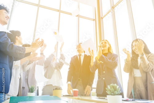 Group of diverse business people celebrating success with raised hands in the office