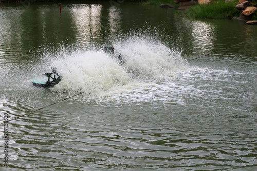 Tableau sur toile Water aerator machine creating splashes and bubbles in a pond