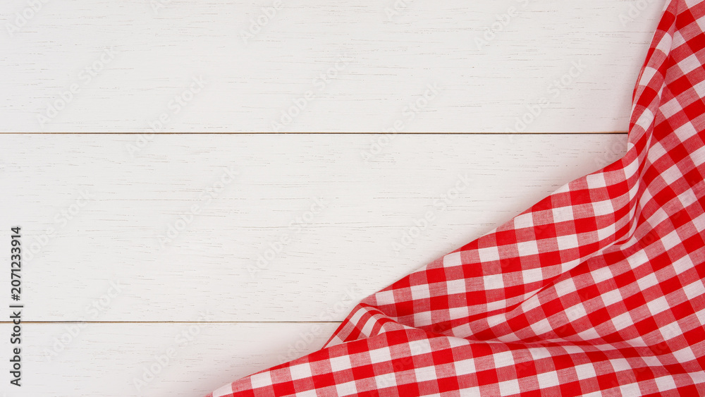 Obraz premium Wrinkled red gingham fabric on rustic white wood plank background, with copy space.