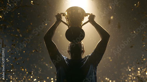 Man holding up a trophy cup.