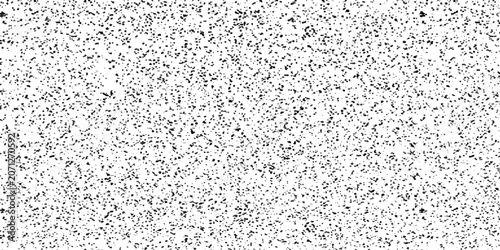 Фотография A speckled texture background with a random, scattered pattern of dark dots on a white canvas, creating a noise-like or granular visual effect