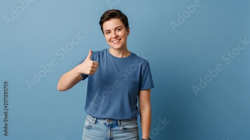 Young woman giving thumbs up on blue background