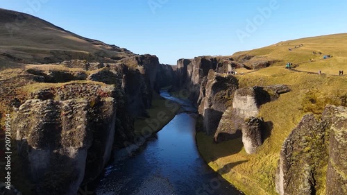 Aerial drone perspective flying low over the river inside Fjadrargljufur canyon in Iceland