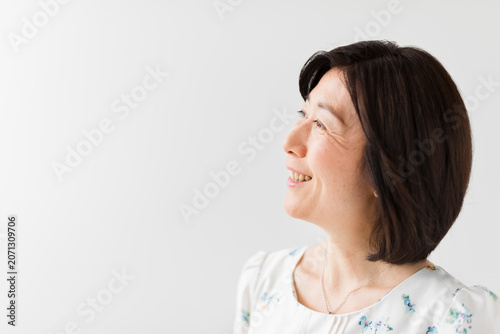 Fotografie 見上げる花柄ワンピースの40代女性の横顔