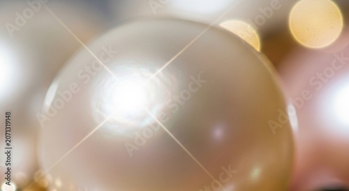 Luminous Pearl: A close-up shot captures the lustrous sheen of a single, perfect pearl, its surface reflecting a soft, warm light amidst a bokeh of golden orbs.