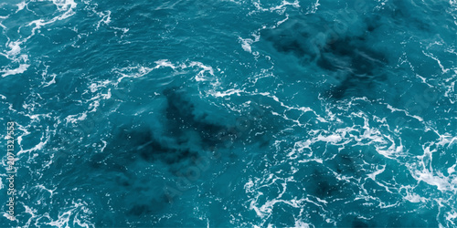 Foto An aerial view captures the dynamic motion of deep blue ocean water, with frothy white waves creating intricate patterns on the surface, hinting at the depths below
