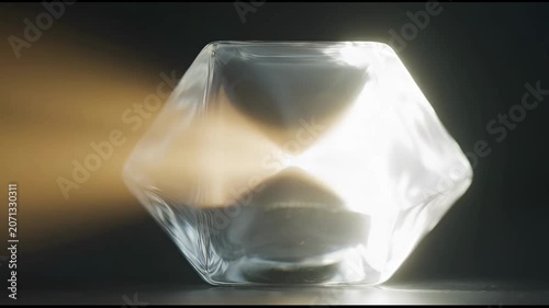 The video features a transparent, geometrically shaped object that appears to be a glass or crystal container
