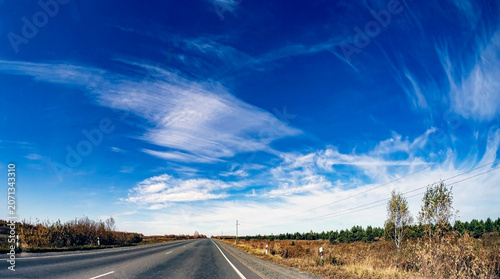 view of the autumn road from the windshield of a suburban car