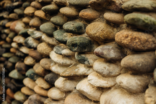 Billede på lærred Background with the texture of a stone wall made of pebbles