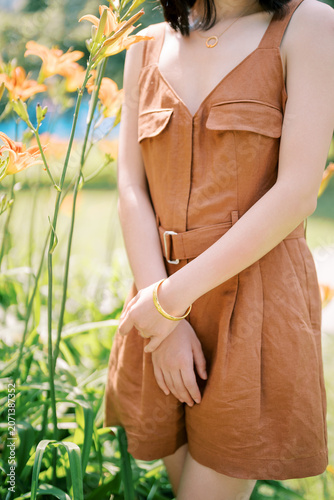 Canvas Print Woman in Brown Dress with Gold Jewelry Among Orange Lilies in Toronto Garden