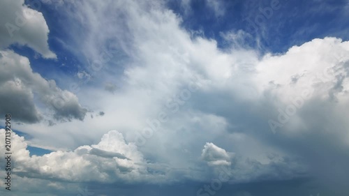 Time lapse video featuring heavy cumulus and storm clouds moving across a deep blue sky background. Dramatic weather transition with high contrast lighting and moody atmosphere