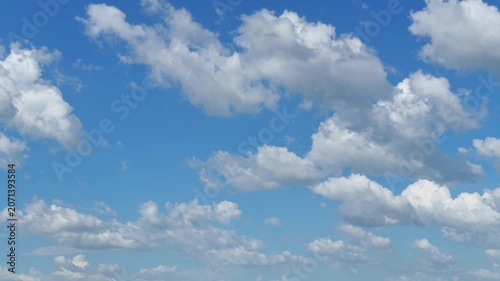 Time lapse video of fluffy white cumulus clouds drifting through a clear blue sky background. Beautiful nature scenery with soft sunlight and airy atmosphere for motion graphics