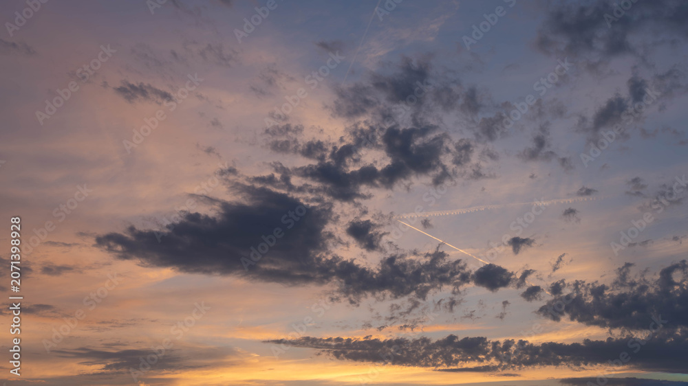 Fototapeta premium Dramatic Sunset Sky with Dark Clouds - Purple and Orange Evening Atmosphere