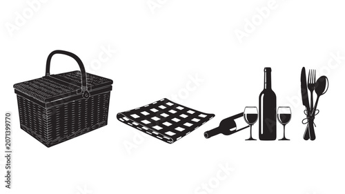 Picnic basket and wine set with fresh vegetables on black grid mat.