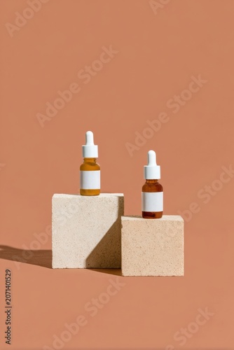 Skincare dropper bottles on geometric stone podium for luxury cosmetic beauty branding mockup with warm earth tones, studio lighting, and ample copy space background