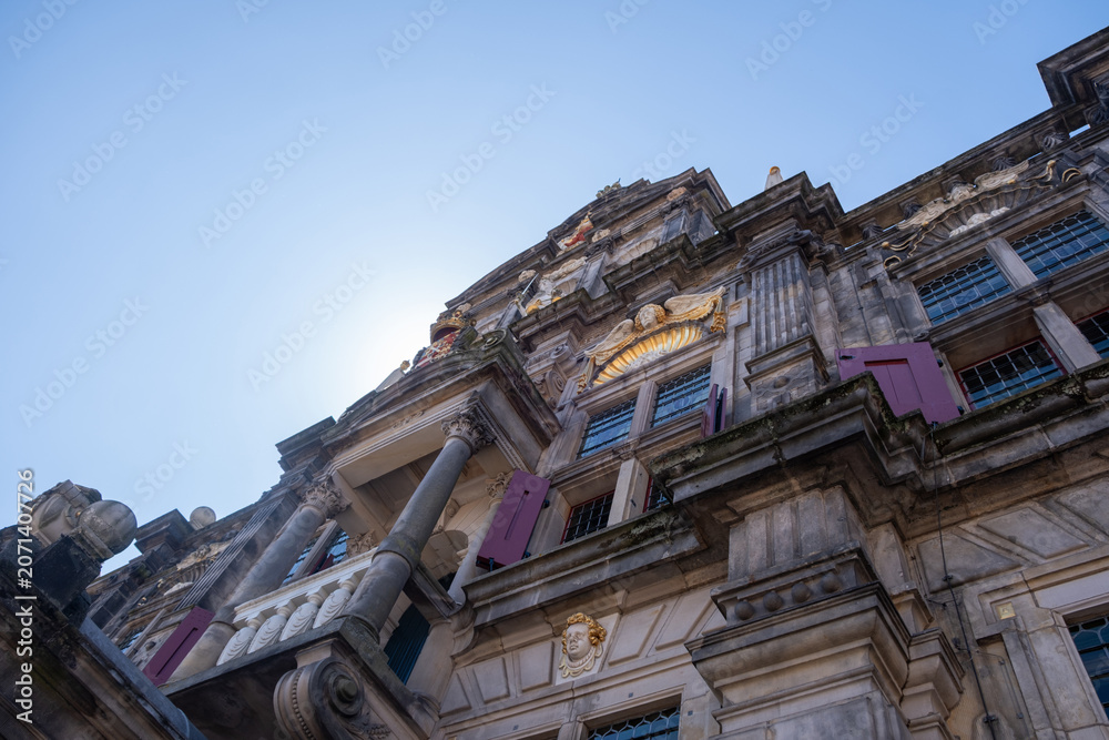 Naklejka premium Ornate Delft City Hall facade from below under blue sky in Delft Netherlands