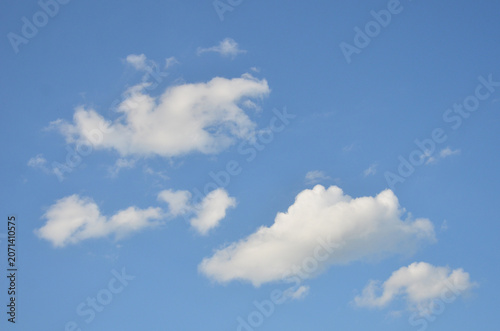 Blue sky with several white fluffy clouds . Nature,  sky in sunny day ,beautiful weather, natural environment .	